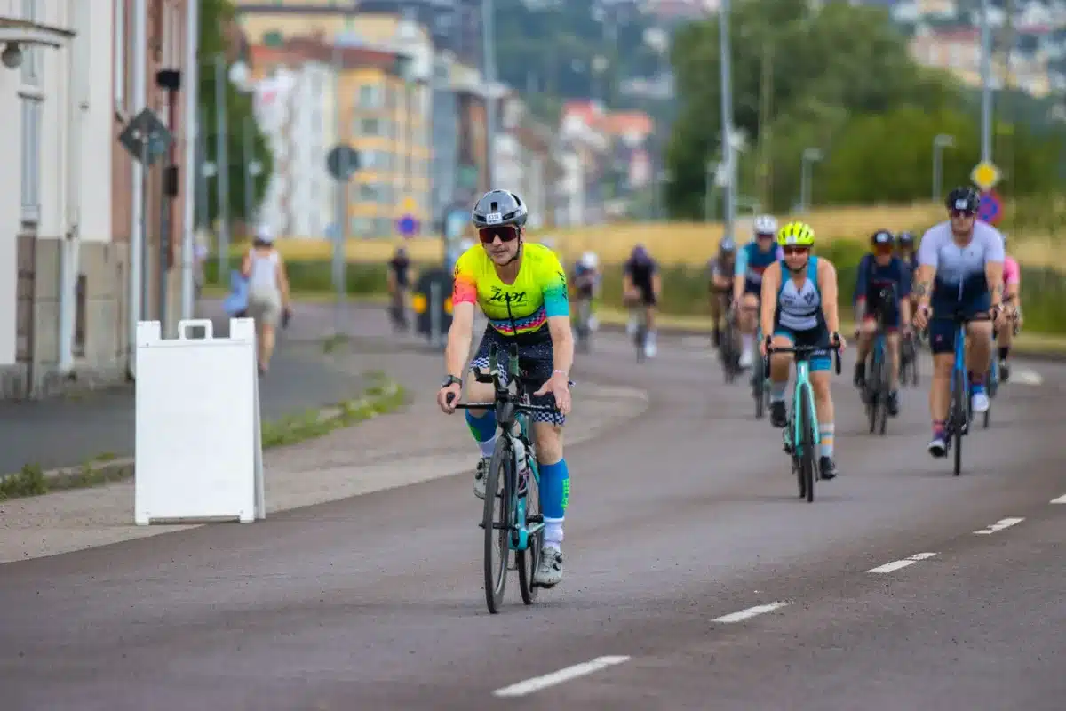 Pelotón de ciclistas compitiendo en carretera costera de Nordland durante una etapa de la Arctic Race