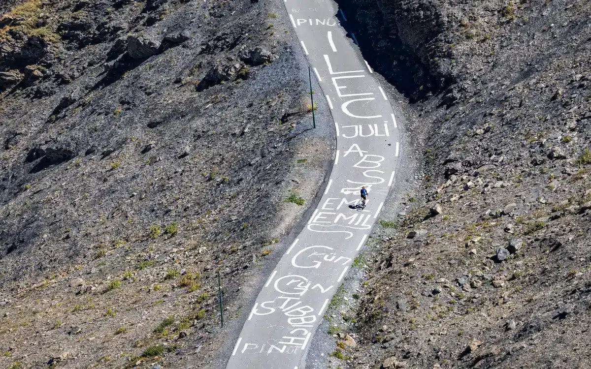 Ciclista en esfuerzo máximo durante ascenso a puerto de montaña en alta altitud