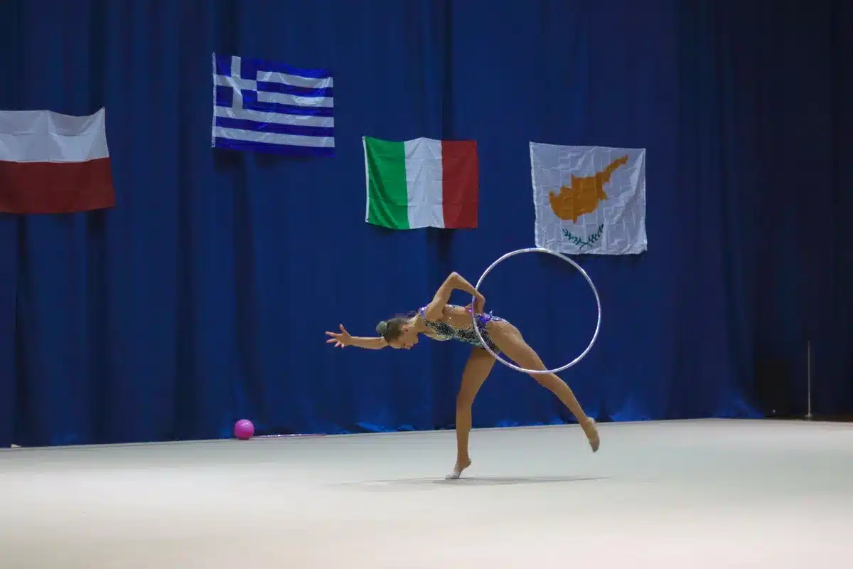 Equipo español de gimnasia rítmica en formación durante una rutina de conjunto con aros y mazas