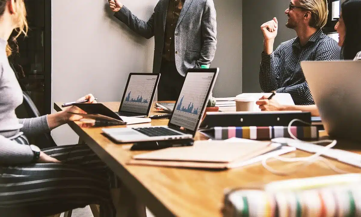 Ejecutivos en una sala de reuniones corporativa durante una conversación tensa, con documentos sobre la mesa