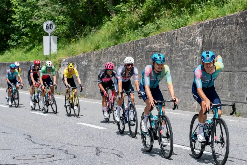 Ciclista joven escalando una montaña en carretera con concentración