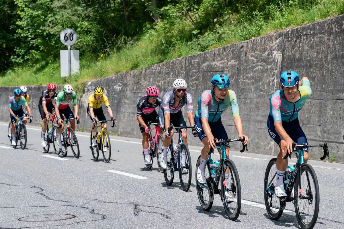 Ciclista joven escalando una montaña en carretera con concentración