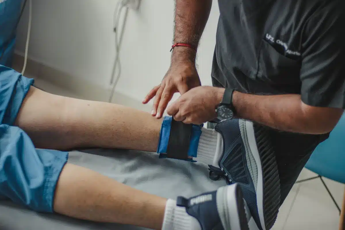 Sesión de fisioterapia y recuperación de un atleta tras lesión en el deporte de élite.