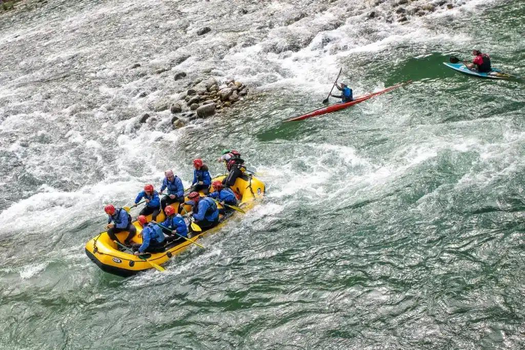 Palista en competición de piragüismo en aguas bravas navegando puertas en un canal con rápidos.
