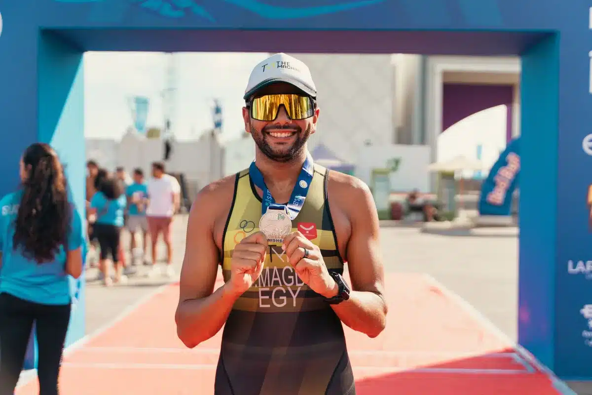 Atleta celebrando una medalla de bronce en el podio de una competición de atletismo