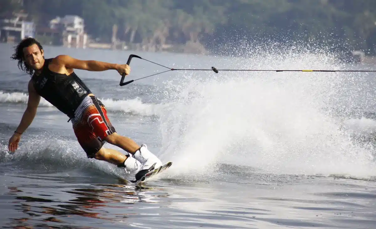 Esquiador náutico pasando entre boyas en una prueba de slalom con precisión técnica.