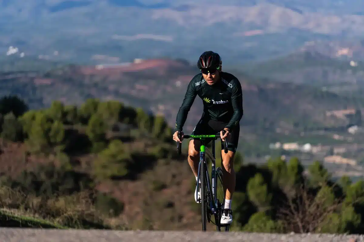 Ciclista escalando una montaña durante una etapa de carrera profesional