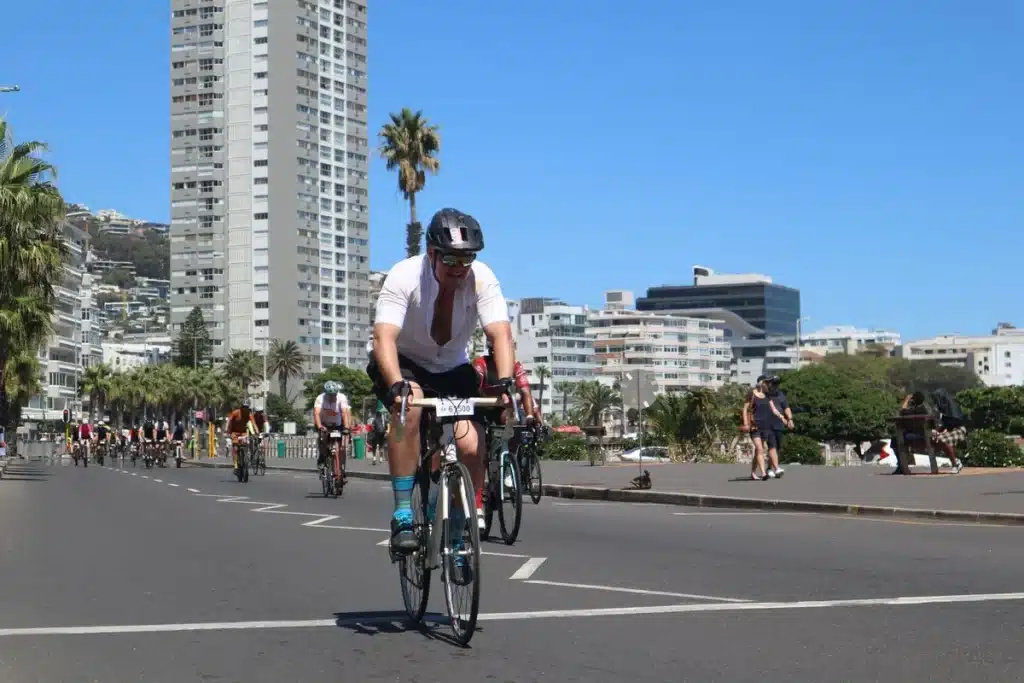 Ciclistas alineados en la salida de una carrera, con sus bicicletas y equipamiento deportivo listo para competir.