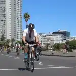 Ciclistas alineados en la salida de una carrera, con sus bicicletas y equipamiento deportivo listo para competir.