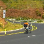 Ciclistas subiendo una montaña empinada en formación táctica durante una carrera de ciclismo