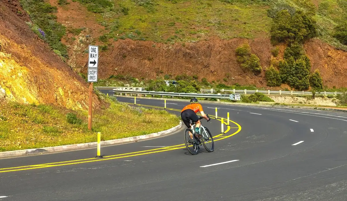 Ciclistas subiendo una montaña empinada en formación táctica durante una carrera de ciclismo