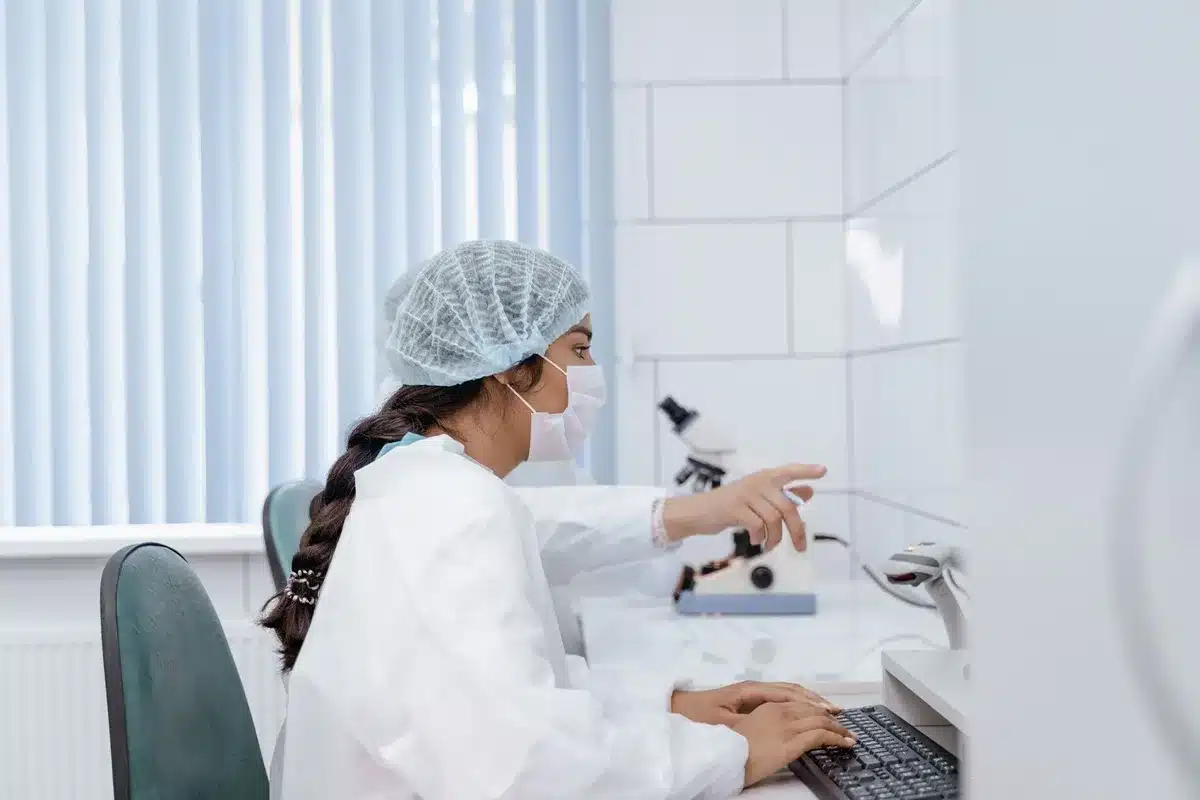 Técnico de laboratorio junto a contenedores de vitrificación en clínica de fertilidad