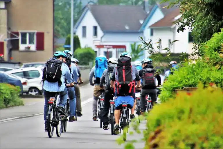 Ciclista solitario en carretera montañosa con perseguidores al fondo