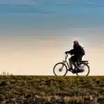 Grupo de ciclistas anónimos subiendo por laderas volcánicas al amanecer