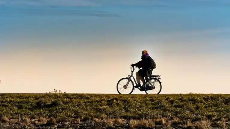 Grupo de ciclistas anónimos subiendo por laderas volcánicas al amanecer