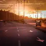Ciclista joven en kit de equipo ascendiendo una carretera de montaña con picos nevados de fondo