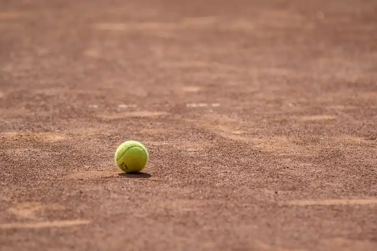 Jugador levantando un trofeo de Grand Slam en pista de tenis
