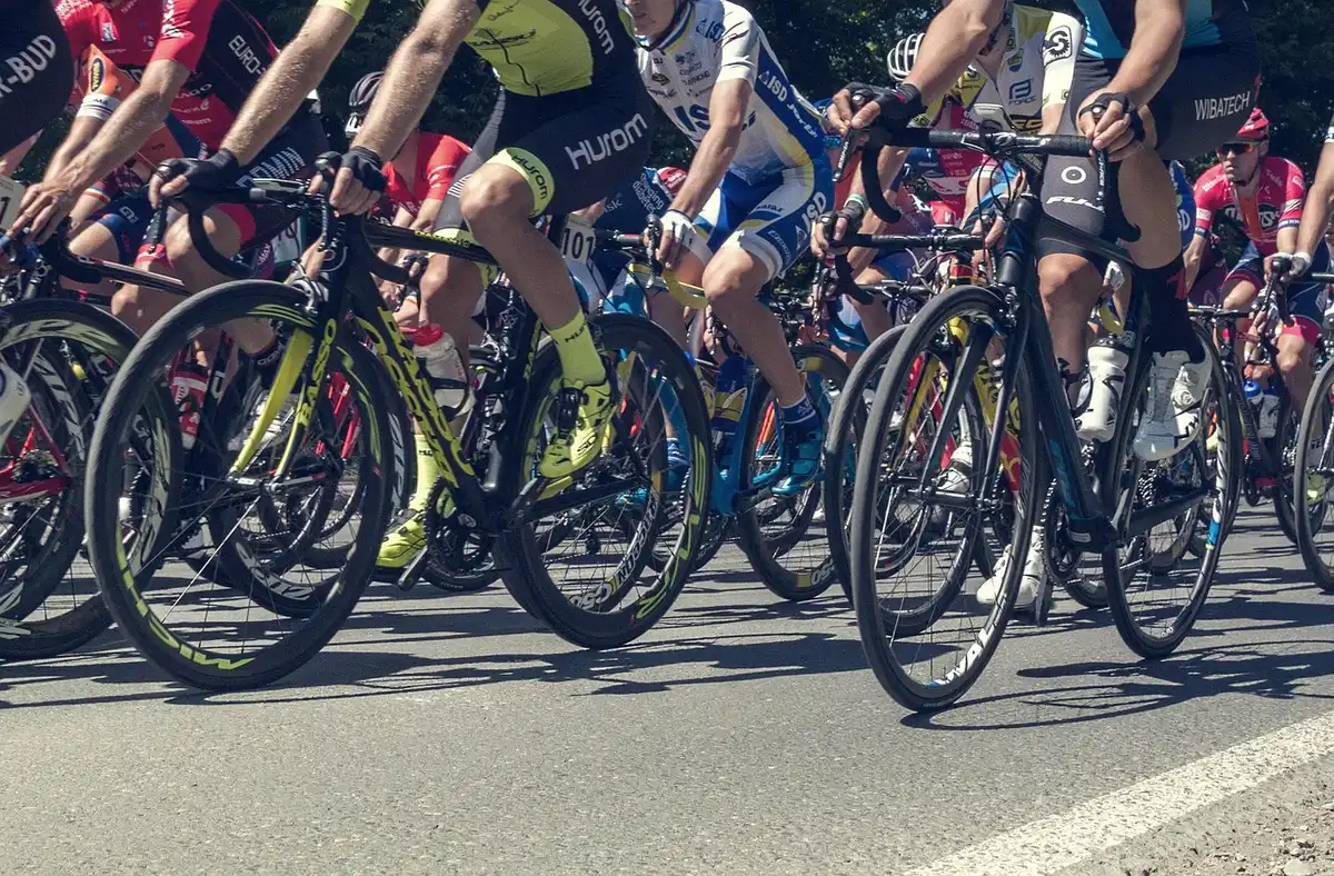 Pelotón ascendiendo por una subida arbolada durante la carrera