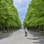 Ciclista anónimo rodando en solitario por una subida de parque urbano