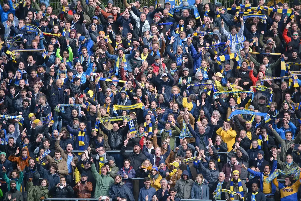 Escena de aficionados en estadio visitante celebrando un gol del Barcelona