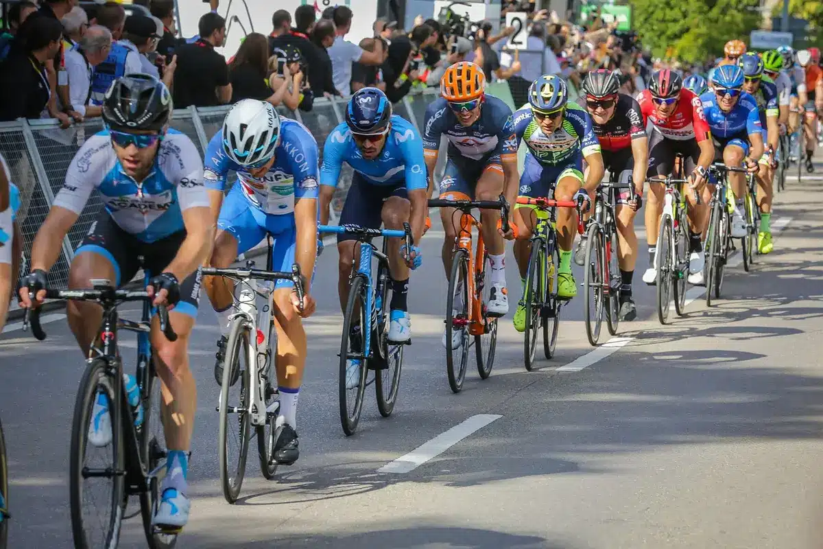 Ciclistas anónimas avanzando por una carretera rural hacia un bulevar