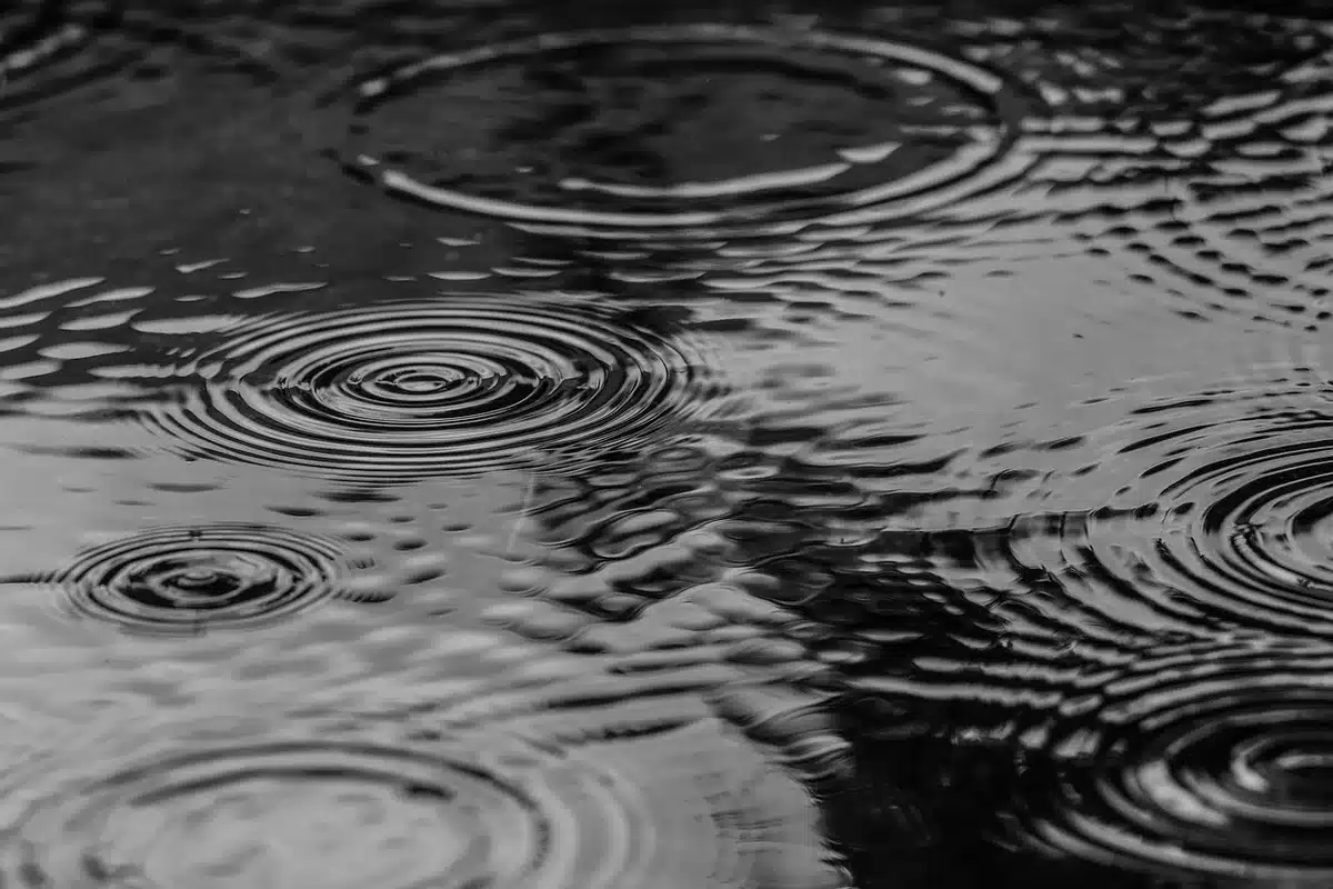 Escapada de ciclistas en carretera con lluvia que ilustra la caída y el desgaste